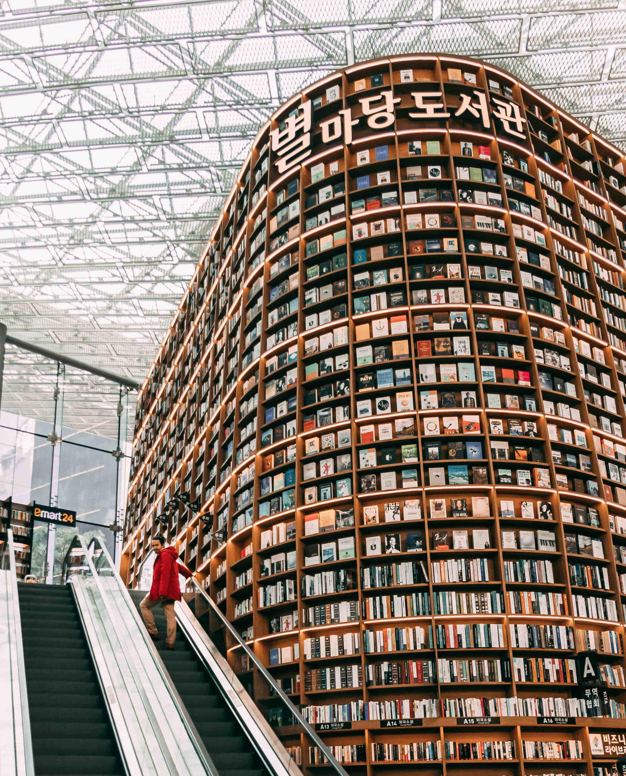 Starfield Library at COEX Mall in Seoul featuring towering curved bookshelf and escalator with visitor